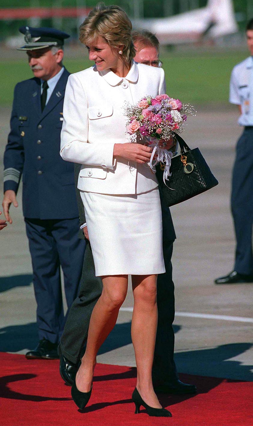 Η πριγκίπισσα Diana φτάνει στο αεροδρόμιο του Μπουένος Άιρες για την ιστορική της επίσκεψη στην Αργεντινή. Η πριγκίπισσα φοράει ένα λευκό κοστούμι σχεδιασμένο από τον σχεδιαστή μόδας Versace και κρατάει μια μαύρη τσάντα Christian Dior.