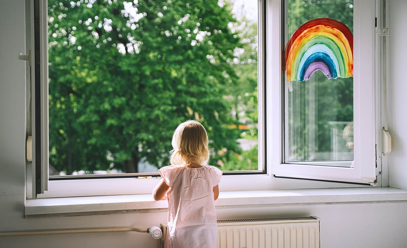 Μιρκό παιδάκι μπροστά σε ανοικτό παράθυρο χαζεύει. Αερίζεται το δωμάτιο.