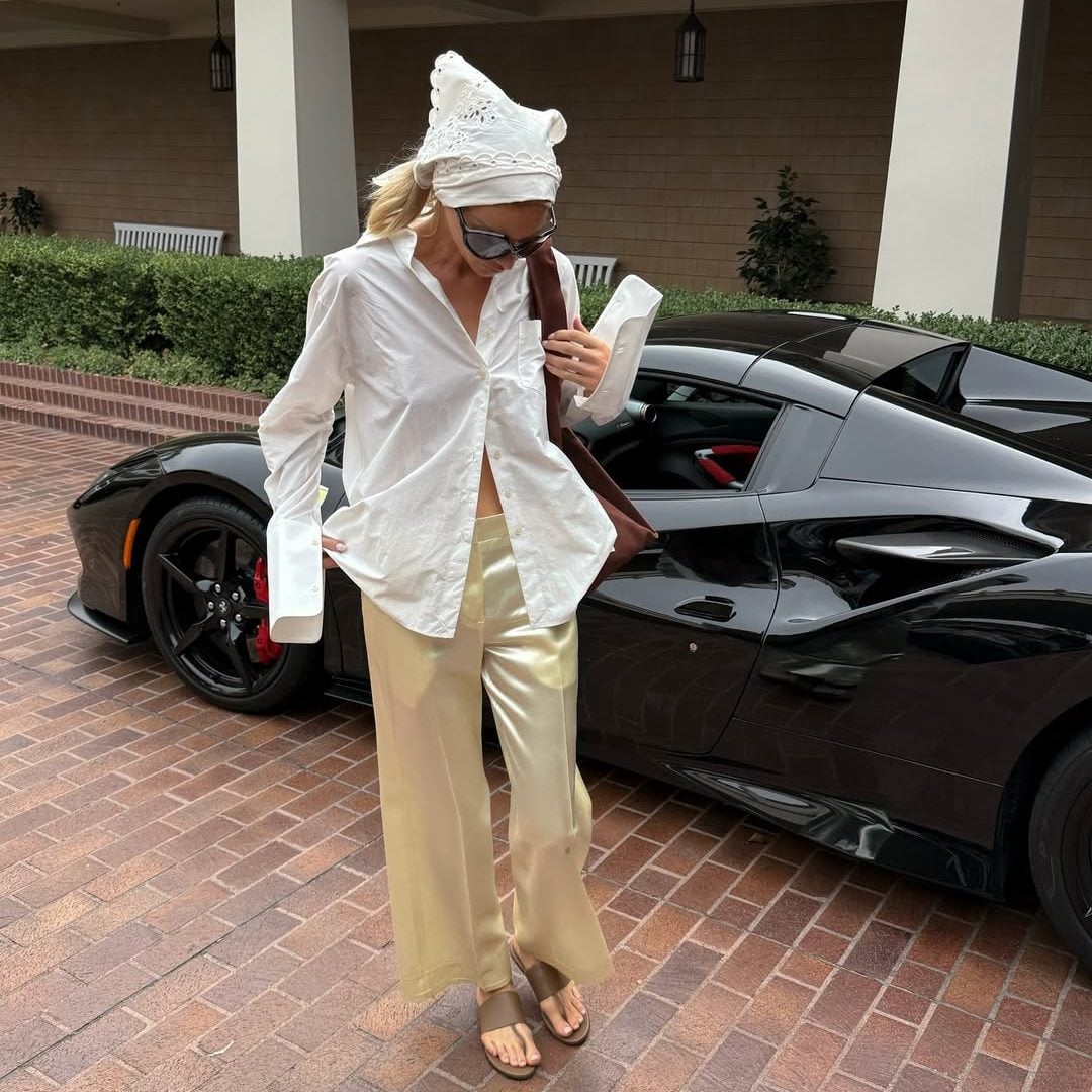 Η Elsa Hosk με casual chic look, φορώντας λευκό πουκάμισο, μεταξωτό παντελόνι, μπαντάνα και stretch thong πέδιλα.