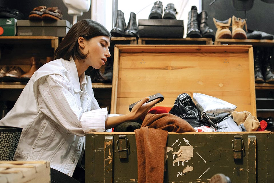 Γυναίκα που ψάχνει vintage ρούχα σε μπαούλο - Vinted resale fashion trends